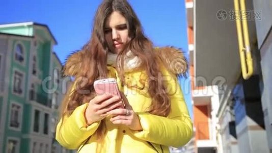美丽的女人用智能手机技术应用程序穿过城市街道，生活在城市，快乐生活视频
