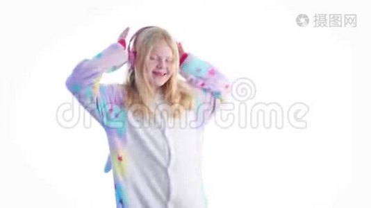 现代时尚-美丽的金发女孩听音乐带着耳机，在基古鲁米的白色背景下跳舞视频