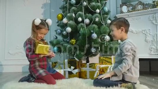弟弟妹妹拆开礼物。 圣诞节和新年的概念视频