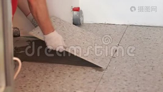 公寓和房屋的修缮和装修.. 专业人员在浴室的地板上铺设瓷砖。视频