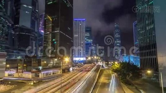 香港商业区夜间时间推移。 公司大楼在后面，繁忙的交通穿过主干道。视频