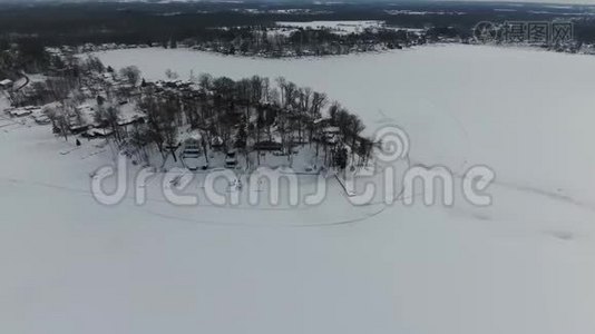 在冰雪覆盖的房屋上飞翔，在冰冻的湖滨视频