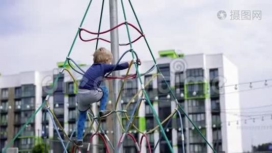 孩子们在现代城市的生活-小男孩在房子附近的操场上玩得很开心视频