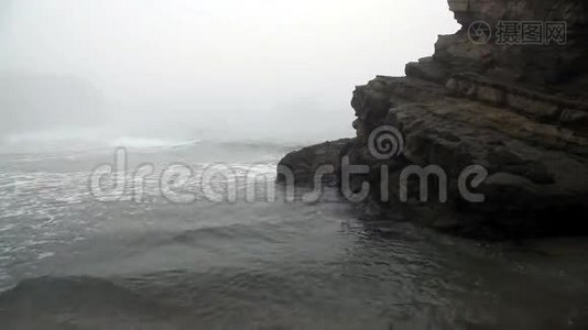 雾笼罩的波浪围绕着大岩石移动视频
