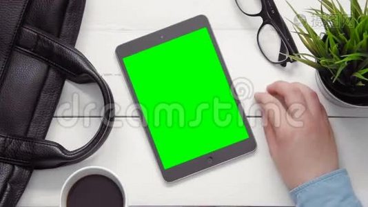 从上图可以看到男性双手在平板电脑上显示多种手势，上面是白色桌面上的绿色屏幕视频