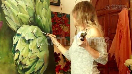 年轻的女艺术家在一个画洋蓟的工作室工作视频