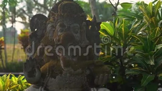 一个热带花园里长满苔藓的甘尼莎神的石像的慢动作稳定镜头视频
