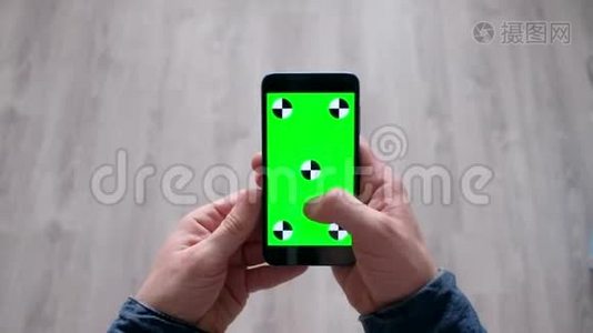 男性使用带有绿色屏幕的智能手机视频