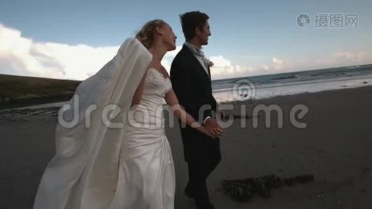 快乐的新婚夫妇在海滩上散步亲吻视频