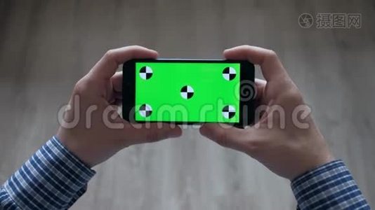 男性使用带有绿色屏幕的智能手机视频
