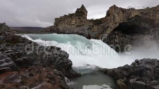 强大的汹涌的白水瀑布有力地落在岩石边缘。 水晶般清澈的冰川水流在cl上落下视频