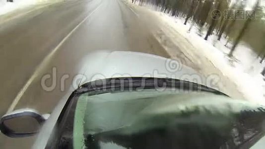 在森林的冬季道路上行驶时，摄像机安装在汽车上。 它会变成雪。视频