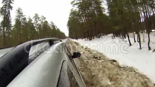 在森林的冬季道路上行驶时，摄像机安装在汽车上。 它会变成雪。视频