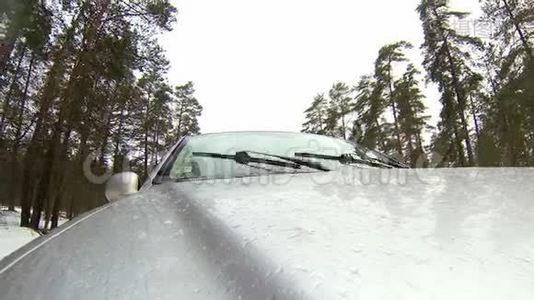 在森林的冬季道路上行驶时，摄像机安装在汽车上。 它会变成雪。视频