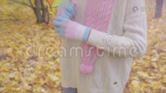秋天公园里，可爱的少女带着彩色雨伞微笑视频