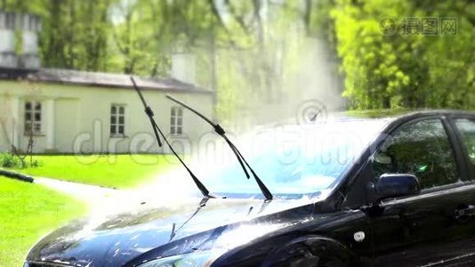 工人在院子里用高压喷水冲洗汽车。视频
