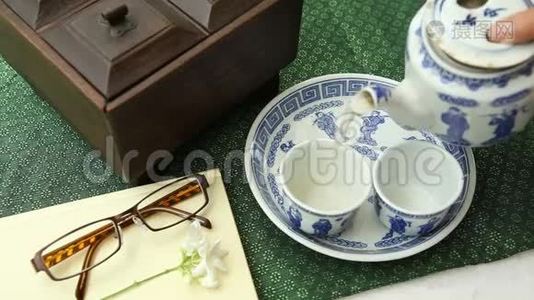 桌上有眼镜、书和木箱的中国茶视频