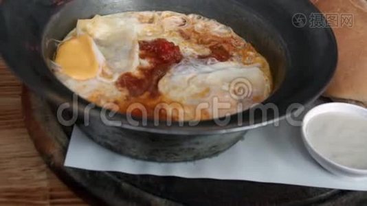 沙克舒卡用番茄和面包在煎锅里煮鸡蛋。 以色列阿拉伯中东菜视频