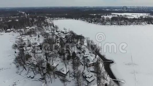 在冰雪覆盖的房屋上飞翔，在冰冻的湖滨视频