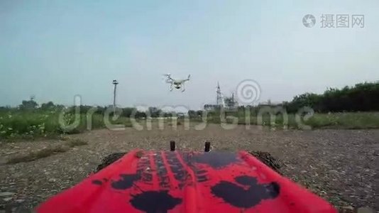RC汽车带着摄像机在土路上行驶，拍摄了四架直升机在汽车前飞行视频
