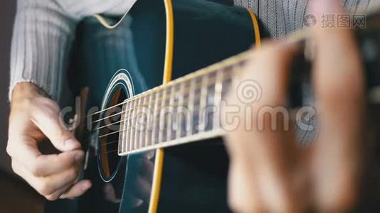 弹声吉他的人。 振动弦的缓慢运动。 慢动作视频