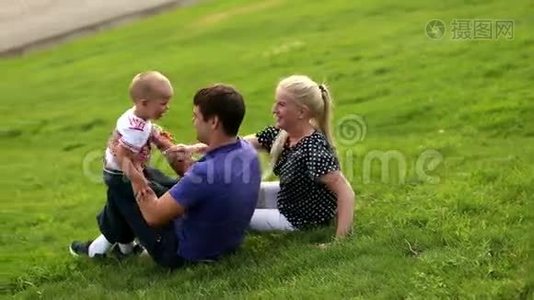 幸福的家庭父亲，母亲和小男孩在夕阳的背景下玩耍。 儿子健康快乐的家庭视频