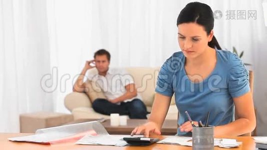 当男朋友在沙发上的时候，女人在计算账单视频