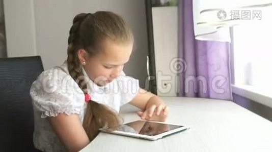 十几岁的女孩在桌子上用数码平板电脑视频