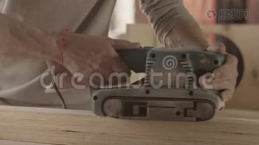 木工用砂带打磨机仔细加工木板表面。视频