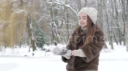 快乐的年轻女孩在公园里吐着雪和笑。 慢慢地视频