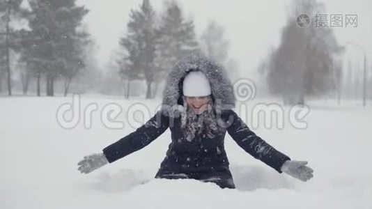 在冬天的公园里快乐地散步。 在雪地里快乐的女人视频