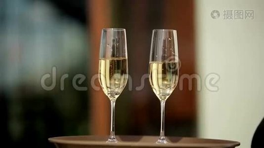 服务员拿着一盘两杯香槟酒向客人展示。 快关门。视频
