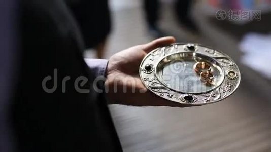 在教堂的金盘上合上豪华的戒指。 婚礼仪式视频