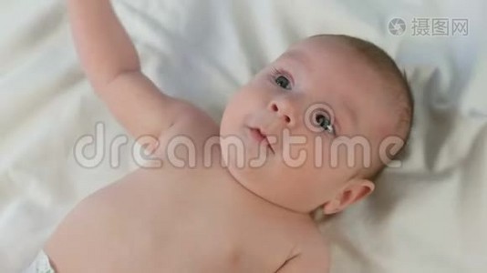 躺在白床上的两个月小婴儿的美丽滑稽肖像视频