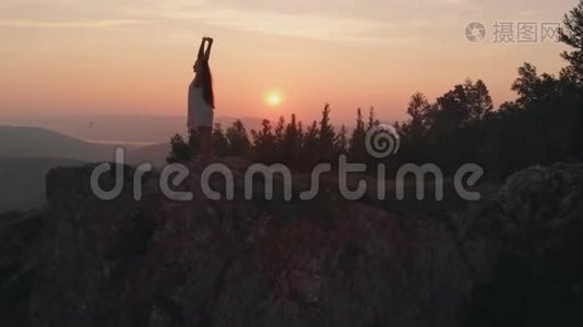 年轻快乐的女人站在悬崖边。视频