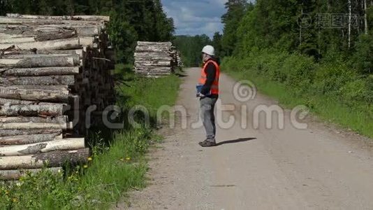 Lumberjack在智能手机上聊天，在一堆木头附近散步视频