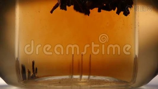 黑叶茶的叶子是用玻璃茶壶冲泡的，慢动作视频
