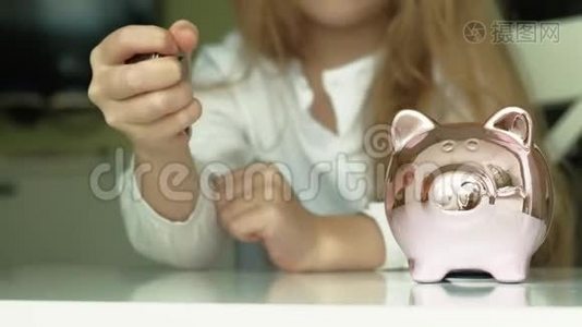 女孩学龄前儿童把钱放在储蓄罐里的粉红猪里视频