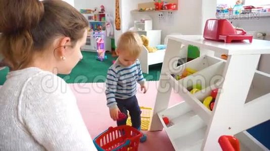 妈妈和她的小男孩在房间里玩，里面有五颜六色的积木、球、厨房视频