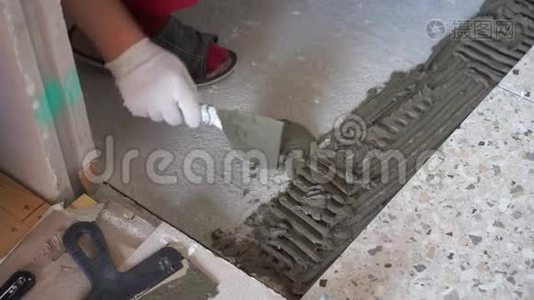 公寓和房屋的修缮和装修.. 专业人员在浴室的地板上铺设瓷砖。视频