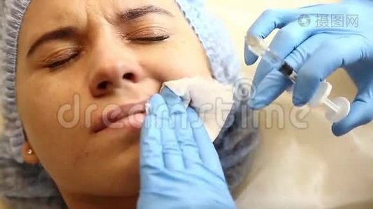 一家诊所的年轻女子在做脂肪增强手术。 麻醉注射硅胶种植嘴唇增厚。 肉毒杆菌注射液视频
