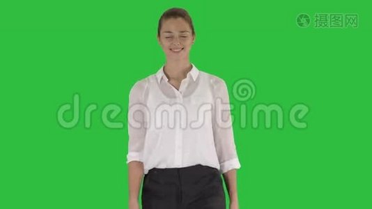 快乐的年轻女商人走在绿色的屏幕上，Chroma键。视频
