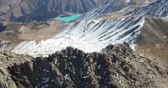 用无人机射击。 飞越多岩石的山脉.. 登山者爬到山顶.视频