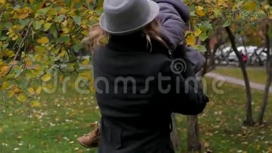 妈妈和女儿在公园里玩，妈妈在树上展示女儿的叶子。 环境研究视频