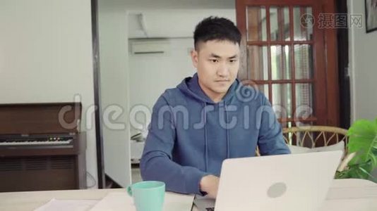 年轻的亚洲夫妇管理财务，在现代家庭使用笔记本电脑和计算器审查他们的银行账户。视频
