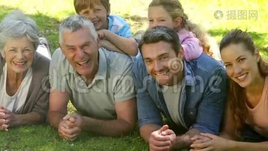 多代家庭微笑着躺在公园的地上视频