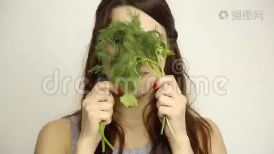 美丽的年轻女人吃蔬菜。 拿着迪尔和欧芹。 健康食物-健康身体概念视频