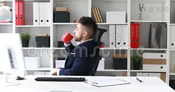 年轻的商人在工作场所喝咖啡。视频