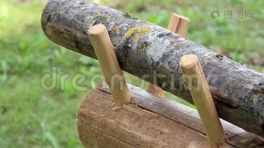 木凳上的一根小圆木，把一根剪成杆状的圆木的图像封闭起来视频