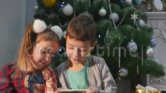 儿童在圣诞树附近玩手机、儿童和智能手机视频